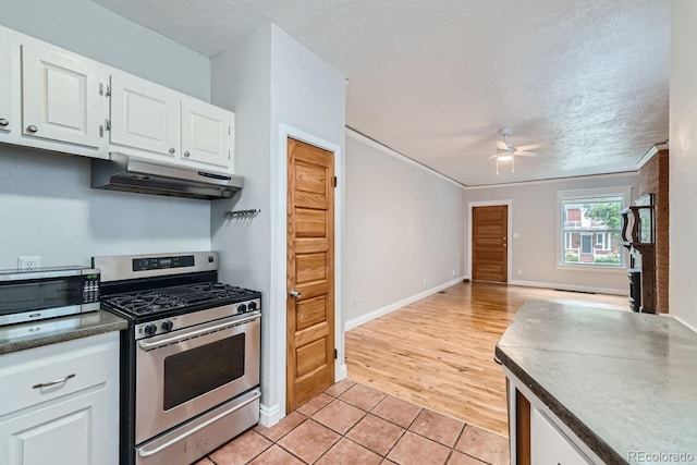 kitchen featuring white cabinetry, a textured ceiling, light tile patterned floors, appliances with stainless steel finishes, and ceiling fan