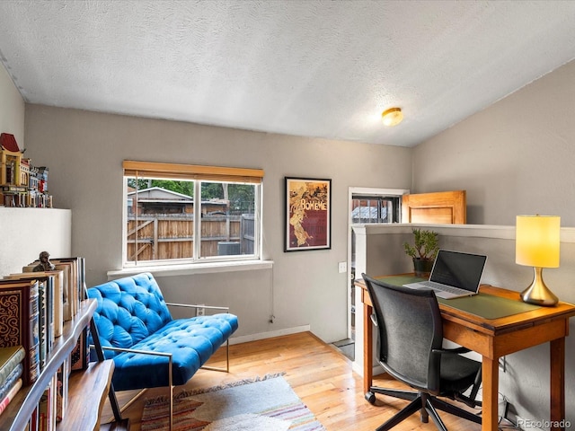 office area with a textured ceiling and light wood-type flooring