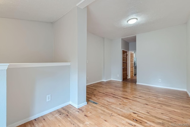 unfurnished room featuring hardwood / wood-style floors and a textured ceiling