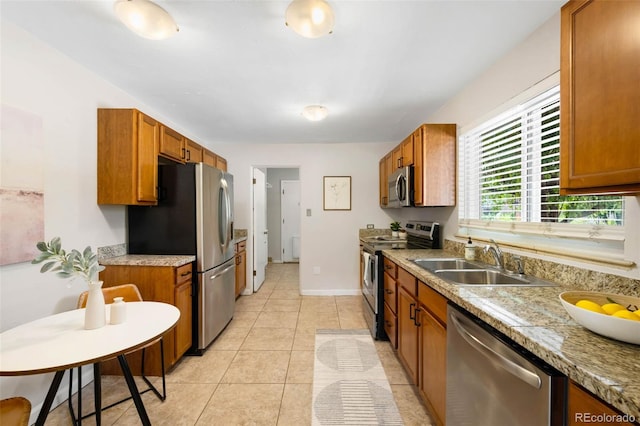 2900 Krameria St, Denver, CO 80207 - kitchen with stainless steel appliances, brown cabinetry, light countertops, and light tile patterned floors