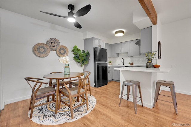 201 Wright St Unit 105, Lakewood, CO 80228 - kitchen with freestanding refrigerator, gray cabinetry, a peninsula, a sink, and light countertops