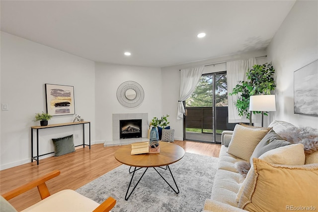 201 Wright St Unit 105, Lakewood, CO 80228 - living area featuring wood finished floors, a tiled fireplace, recessed lighting, and baseboards