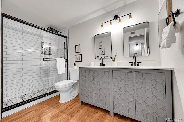 201 Wright St Unit 105, Lakewood, CO 80228 - full bathroom featuring toilet, double vanity, wood finished floors, and a shower stall