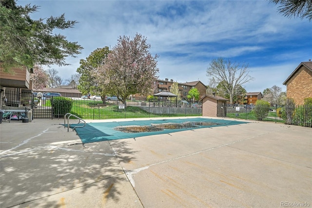 201 Wright St Unit 105, Lakewood, CO 80228 - community pool featuring a residential view, a patio, and an outbuilding