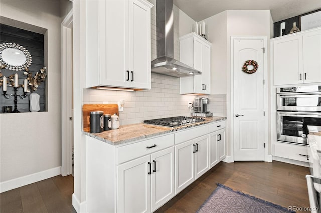 10080 E 160th Pl, Brighton, CO 80602 - kitchen with wall chimney range hood, appliances with stainless steel finishes, dark wood-style flooring, tasteful backsplash, and white cabinets