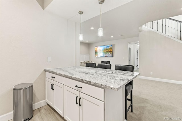 10080 E 160th Pl, Brighton, CO 80602 - kitchen with baseboards, light stone countertops, white cabinetry, pendant lighting, and a kitchen breakfast bar