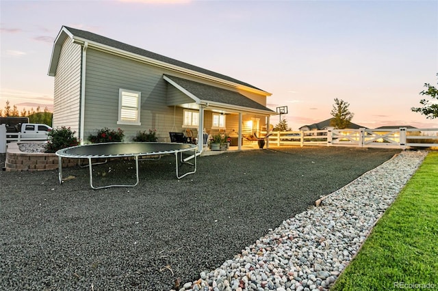 10080 E 160th Pl, Brighton, CO 80602 - back of property featuring a fenced backyard, a trampoline, and a patio