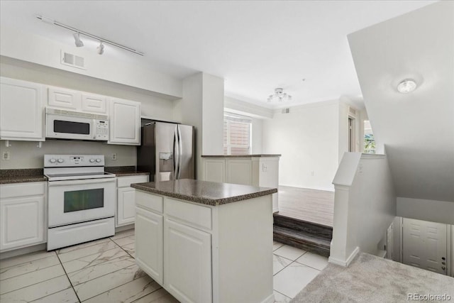 1631 Egret Way, Superior, CO 80027 - kitchen with white appliances, light marble finish floors, dark countertops, a kitchen island, and white cabinets