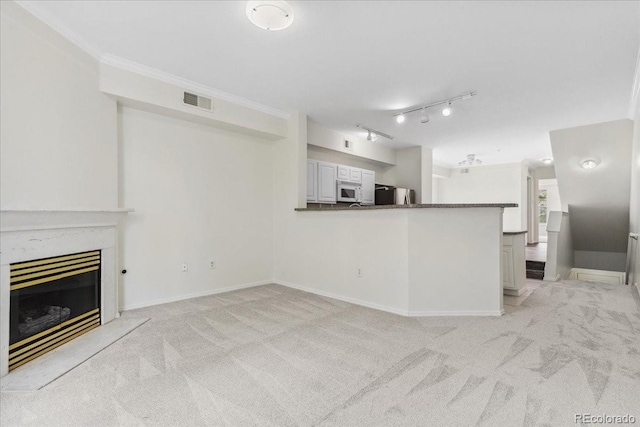 1631 Egret Way, Superior, CO 80027 - unfurnished living room with light colored carpet, a fireplace, baseboards, and crown molding