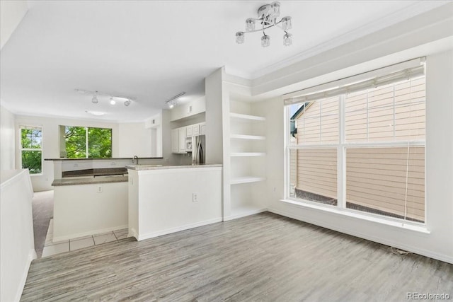 1631 Egret Way, Superior, CO 80027 - kitchen featuring stainless steel refrigerator, light wood-style flooring, a peninsula, white cabinets, and open floor plan