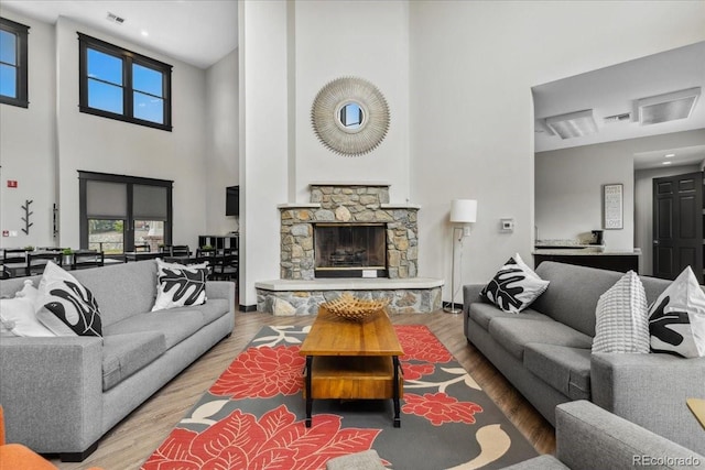 1631 Egret Way, Superior, CO 80027 - living area featuring a towering ceiling, wood finished floors, plenty of natural light, and a stone fireplace