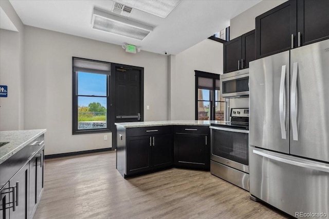 1631 Egret Way, Superior, CO 80027 - kitchen featuring stainless steel appliances, dark cabinetry, light wood finished floors, and a peninsula