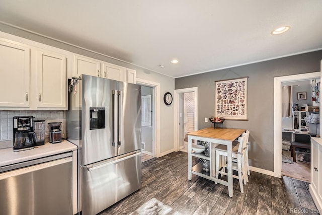 kitchen featuring white cabinetry, appliances with stainless steel finishes, dark hardwood / wood-style flooring, and decorative backsplash