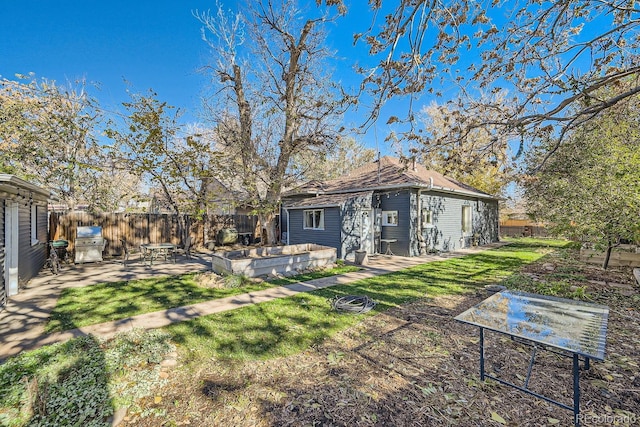 rear view of property featuring an outbuilding, a yard, and a patio area