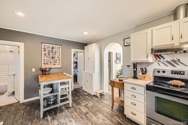 kitchen with decorative backsplash, dark hardwood / wood-style floors, white cabinets, and stainless steel electric range oven