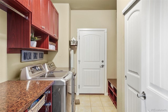 laundry room featuring light tile patterned floors, washing machine and dryer, and cabinets