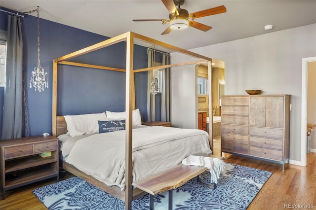 bedroom featuring hardwood / wood-style flooring, ensuite bath, and ceiling fan