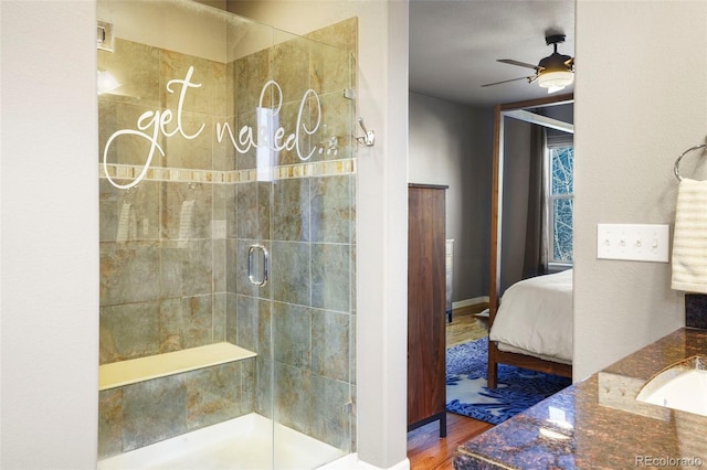 bathroom with ceiling fan, wood-type flooring, an enclosed shower, and sink