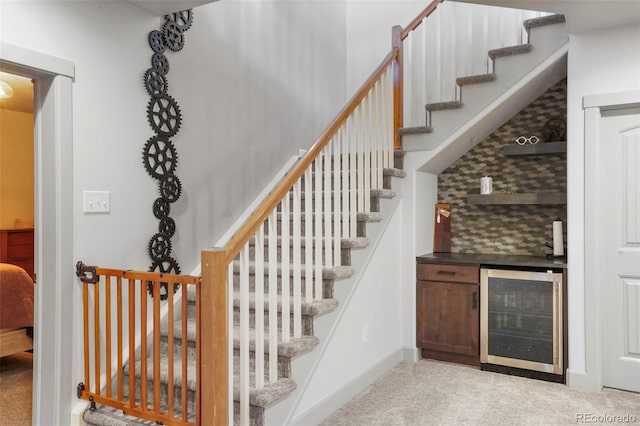 stairs with bar, beverage cooler, and carpet floors