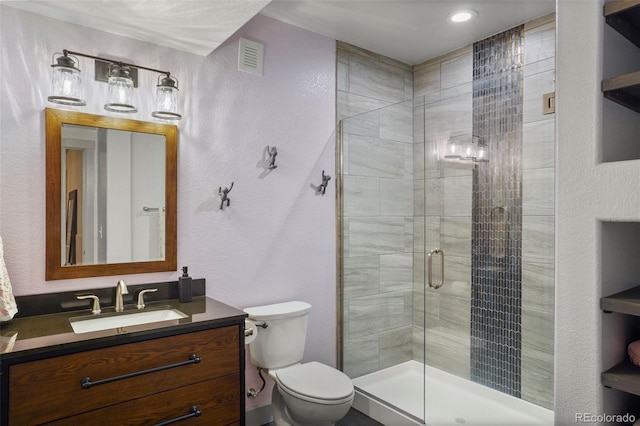 bathroom featuring toilet, vanity, and walk in shower