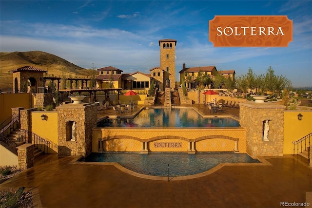 view of pool with pool water feature and a patio