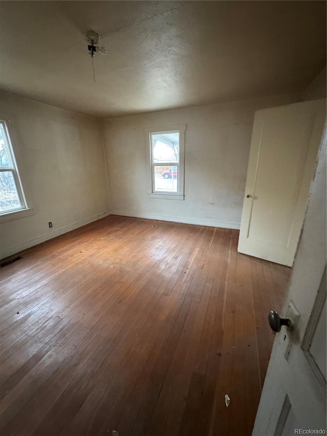 interior space featuring wood-type flooring, visible vents, and baseboards