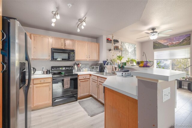 8707 E Florida Ave Unit 410, Denver, CO 80247 - kitchen featuring a sink, light brown cabinetry, black appliances, and light countertops
