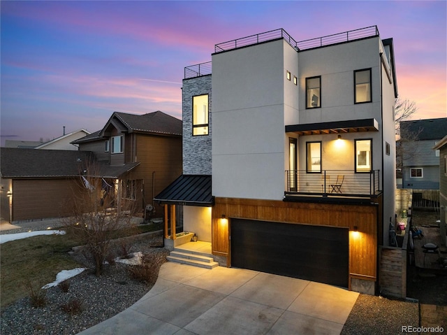 contemporary house featuring a garage and a balcony