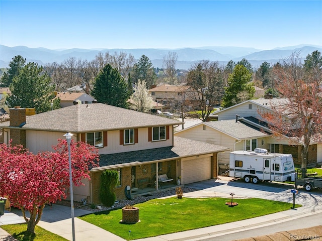 7314 W Walker Pl, Littleton, CO 80123 - view of front of house featuring an attached garage, roof with shingles, a mountain view, and a front yard