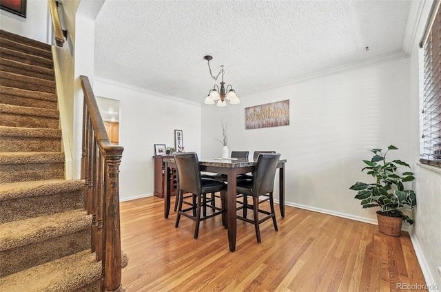 7314 W Walker Pl, Littleton, CO 80123 - dining area featuring stairway, light wood finished floors, ornamental molding, and an inviting chandelier