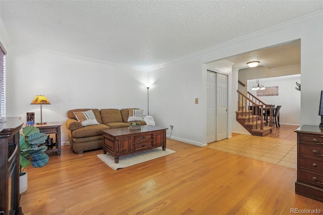 7314 W Walker Pl, Littleton, CO 80123 - living room with an inviting chandelier, crown molding, a textured ceiling, and light wood-type flooring