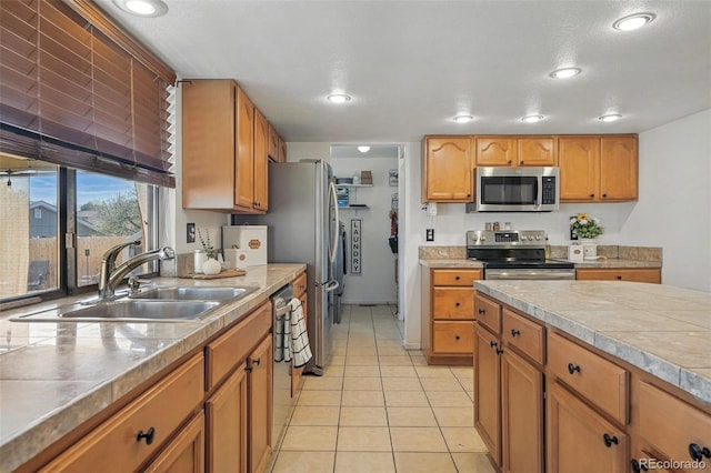 7314 W Walker Pl, Littleton, CO 80123 - kitchen with stainless steel appliances, light countertops, a sink, light tile patterned flooring, and brown cabinetry