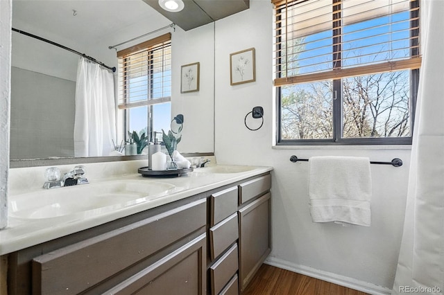 7314 W Walker Pl, Littleton, CO 80123 - full bathroom with wood finished floors, double vanity, a sink, and baseboards