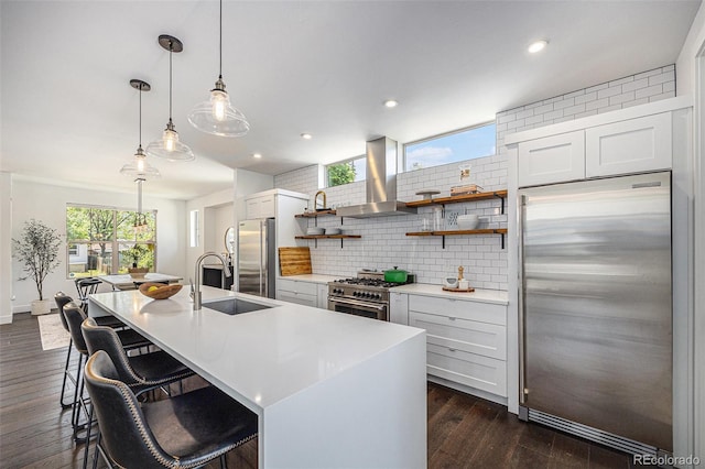 4180 Ames St, Denver, CO 80212 - kitchen featuring appliances with stainless steel finishes, island range hood, decorative backsplash, open shelves, and an island with sink