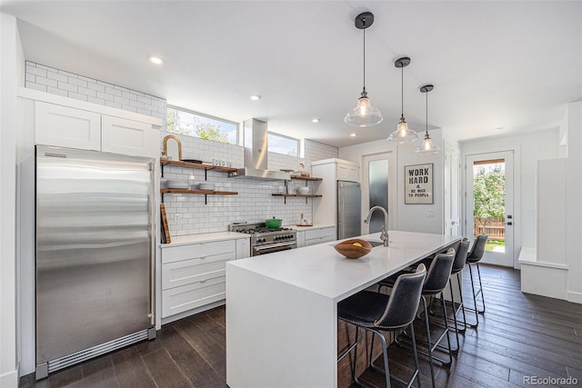 4180 Ames St, Denver, CO 80212 - kitchen featuring premium appliances, range hood, dark wood-type flooring, backsplash, and white cabinetry