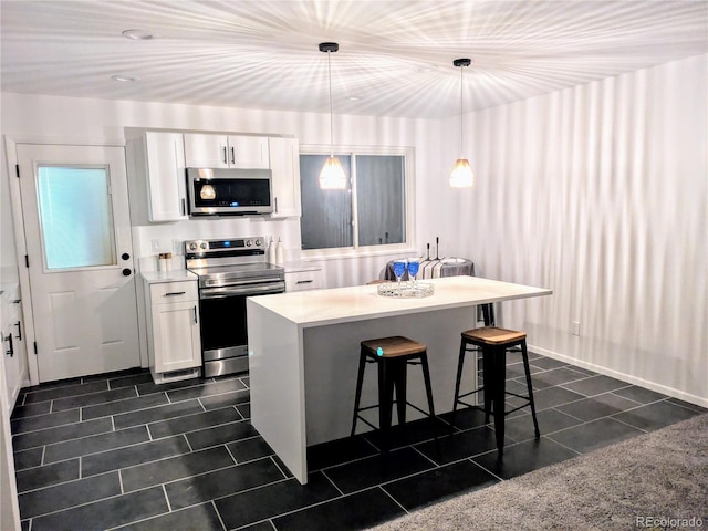 kitchen featuring pendant lighting, a center island, white cabinetry, stainless steel appliances, and a kitchen breakfast bar