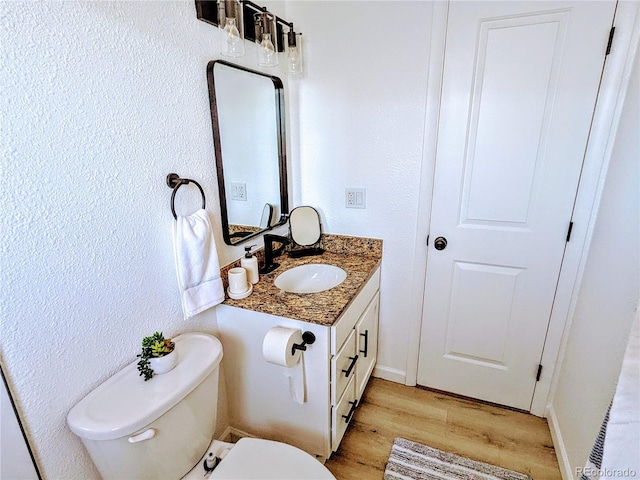 bathroom with hardwood / wood-style floors, toilet, and vanity