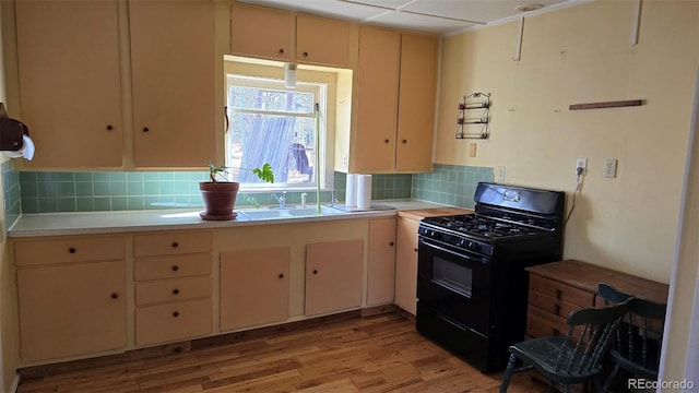 1010 San Juan Ave, Saguache, CO 81149 - kitchen with black gas range oven, light countertops, light wood-type flooring, and tasteful backsplash