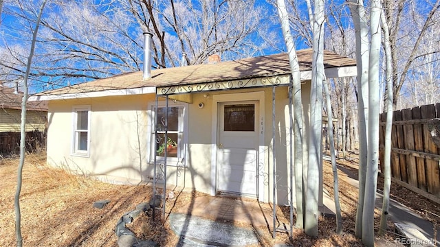 1010 San Juan Ave, Saguache, CO 81149 - entrance to property with stucco siding, a shingled roof, and a chimney