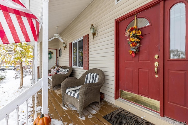 snow covered property entrance with ceiling fan and a porch