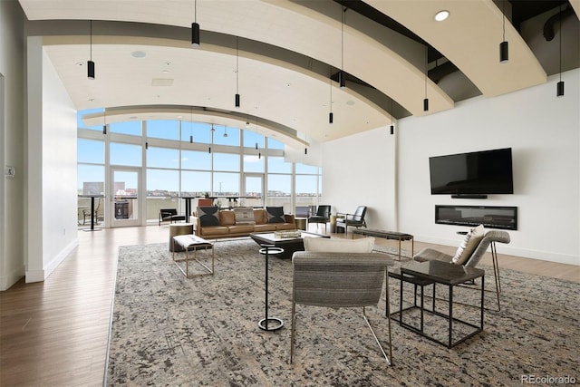 living room with lofted ceiling, wood-type flooring, and a healthy amount of sunlight