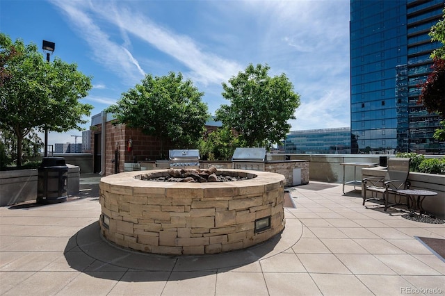 view of patio with exterior kitchen, area for grilling, and an outdoor fire pit