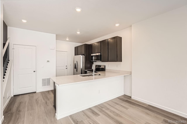 kitchen featuring sink, light wood-type flooring, kitchen peninsula, and stainless steel refrigerator with ice dispenser