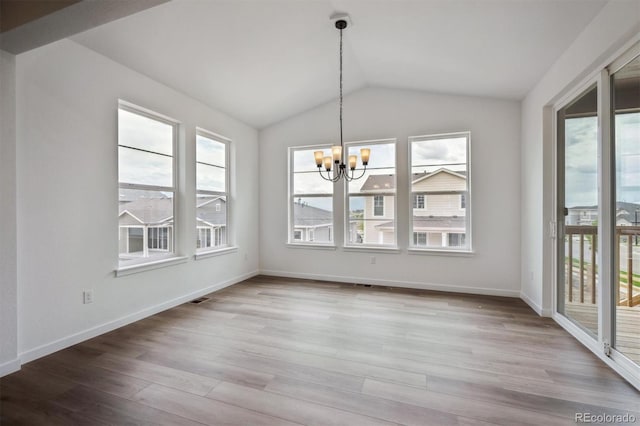 24708 E 40th Ave, Aurora, CO 80019 - unfurnished dining area featuring a chandelier, healthy amount of natural light, wood finished floors, and vaulted ceiling