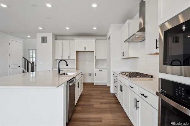 24708 E 40th Ave, Aurora, CO 80019 - kitchen featuring stainless steel appliances, a sink, wall chimney range hood, dark wood-style flooring, and white cabinets