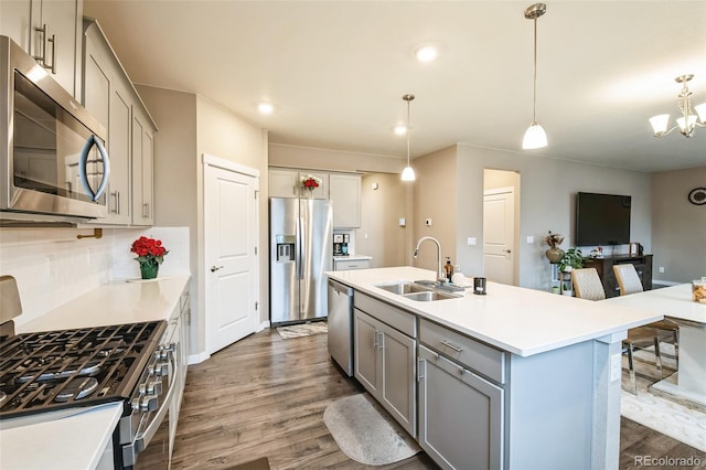833 Vixen Dr, Fort Collins, CO 80524 - kitchen with decorative light fixtures, stainless steel appliances, a kitchen island with sink, gray cabinets, and sink