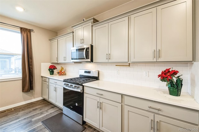 833 Vixen Dr, Fort Collins, CO 80524 - kitchen with appliances with stainless steel finishes, gray cabinets, decorative backsplash, and hardwood / wood-style flooring