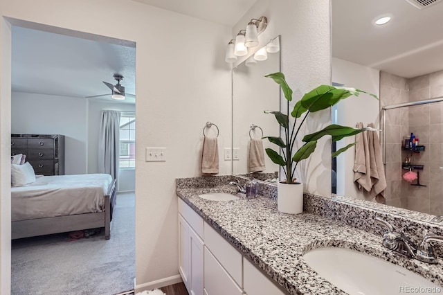 ensuite bathroom with a sink, double vanity, a ceiling fan, and connected bathroom