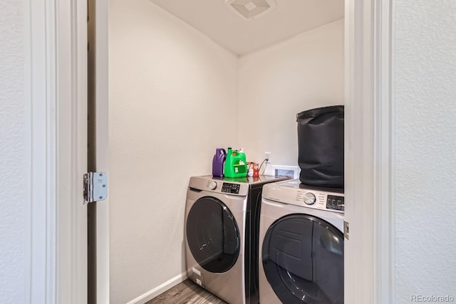 washroom with visible vents, wood finished floors, laundry area, independent washer and dryer, and baseboards