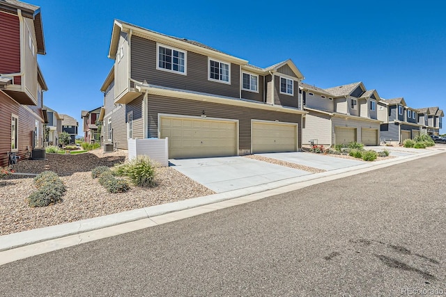 view of property featuring a residential view, concrete driveway, and cooling unit